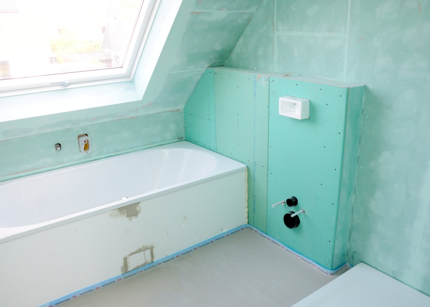 Badezimmer-Rohbau mit Trockenbauwänden, Badewanne und WC-Anschlüssen