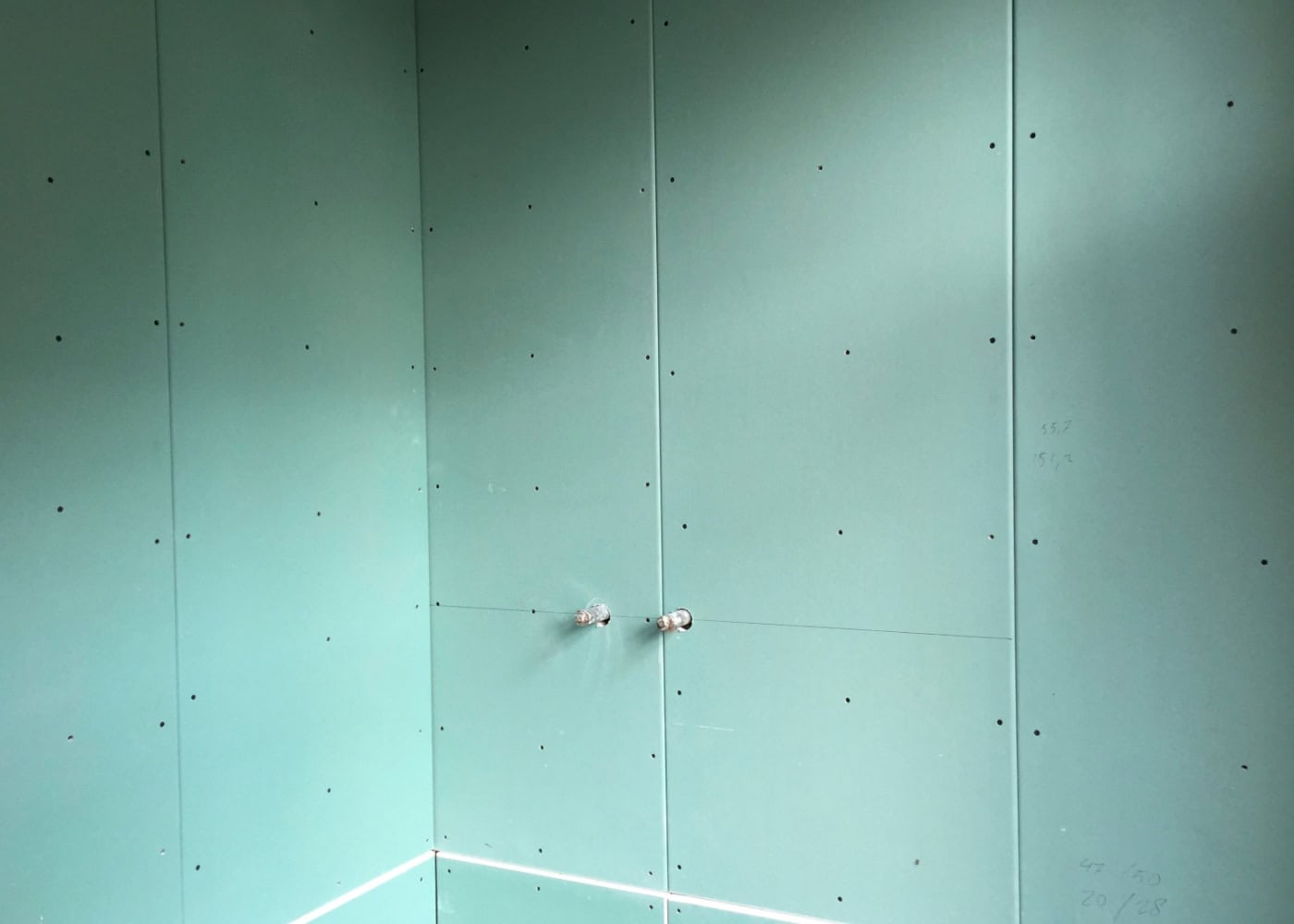 Innenraum mit montierten Trockenbauwänden und vorbereiteten Wasseranschlüssen